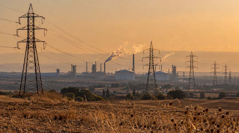 Torres eléctricas y complejo industrial en un paisaje seco durante una ola de calor